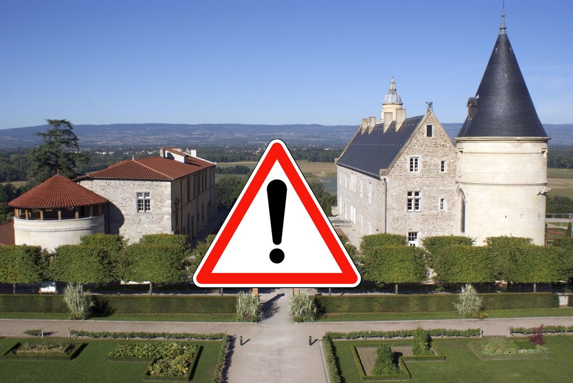 vue atérienne du château de Bouthéon avec un panneau de signalisation "attention" par dessus